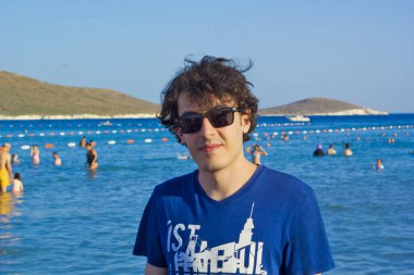 portrait of a handsome man in sunglasses on the beach