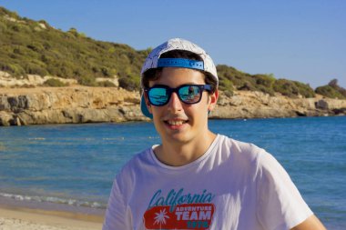 portrait of a handsome man in sunglasses on the beach