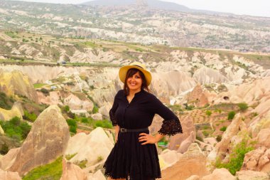 Kapadokya manzarasına bakan beyaz şapkalı güzel kadın, hindi.