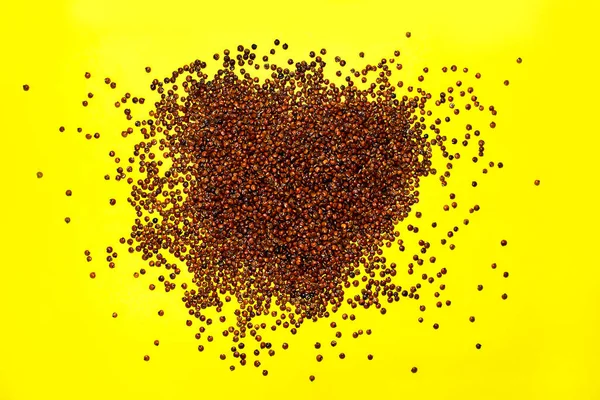 Organic Red Quinoa seed (Chenopodium quinoa) on yellow background.