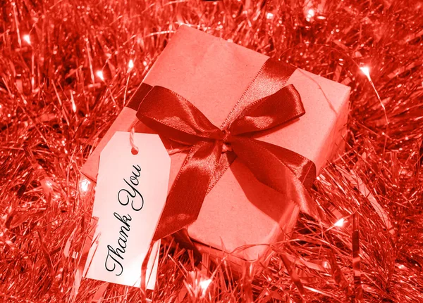 Thank you white tag on Gift box decorated with red bow in Christmas Garland. For Christmas, thanksgiving and New Year Holidays.