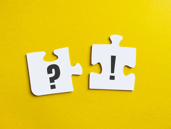 Exclamation point and question mark on puzzle on yellow background. Concept of information guide, questions and answers, FAQ section for banner, poster.