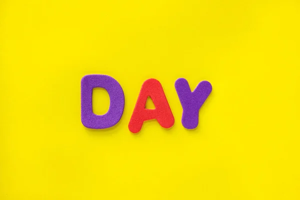 Bunte Tagesbuchstaben Isoliert Auf Gelbem Hintergrund Mit Kopierraum Flache Lage — Stockfoto