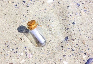 Plajdaki şişe mantarlı bir mesaj. Kumdaki şişe. Kumsaldaki şişe. Güneşli bir gün.