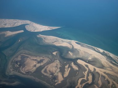 Basra Körfezi deniz burnu, kayalık deniz yatağı mavi sığ suyun altında. Doğal fotoğraf. Kuş bakışı