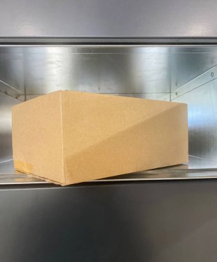 İçinde karton kutu olan gri paketi aç. Otomatik parsel dolap alma makinesi.