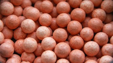 Toz fırçası ve karışık renkli parlak yüzlü inciler parlak arkaplanda kızarıyor. Kopyalama alanı olan üst görünüm.