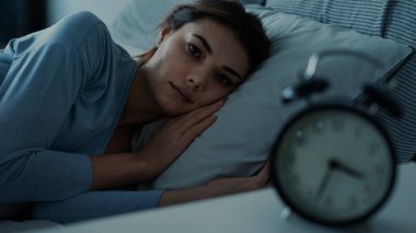  Uykusuzluk çeken genç bir kadın yatakta