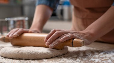 Kadın elleri mutfakta hamur yoğuruyor.