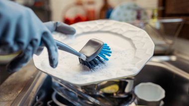 Ev mutfağında bulaşık yıkıyorum.