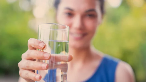 水のガラスを飲む若い女性 ストック写真