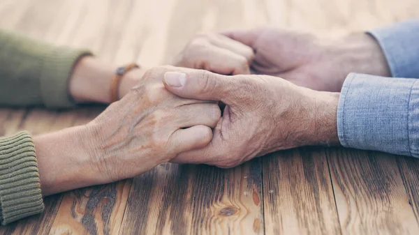 Two people holding hands with compassion and love