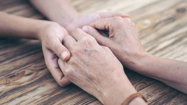 Two people holding hands with compassion and love