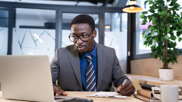 İşadamı ofiste bilgisayarla çalışıyor.