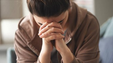 elleriyle yüzünü kaplayan kadın