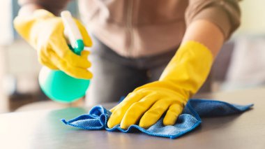 Evdeki oturma odasındaki temizlikçi kadın.