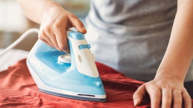 Ütü masasındaki giysileri ütülüyorum.