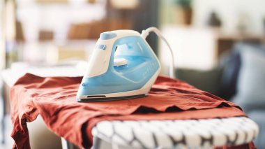 Ütü masasındaki giysileri ütülüyorum.