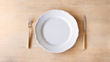 Boş tabak, çatal ve bıçak masaya.