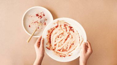 Açlık konsepti. Boş tabağı tutan kadın yemek bekliyor. Üst görünüm