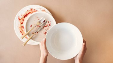 Açlık konsepti. Boş tabağı tutan kadın yemek bekliyor. Üst görünüm