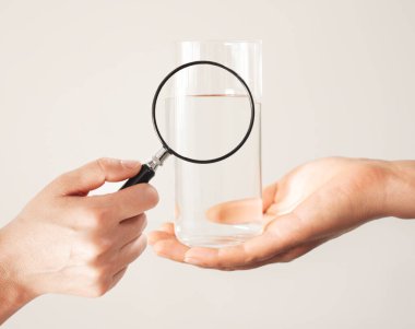 Bir bardaktaki suya büyüteçle bakarak.