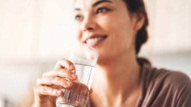 Bir bardak içme suyu tutan kadın.