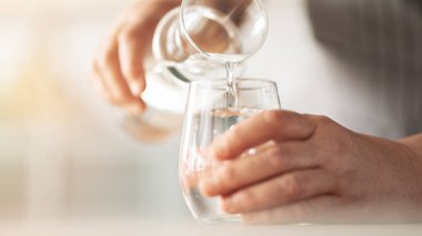 Bir bardak içme suyu tutan kadın.