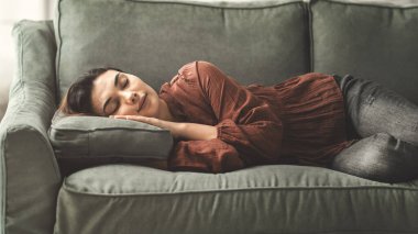 Genç bayan oturma odasındaki kanepede dinlenin.