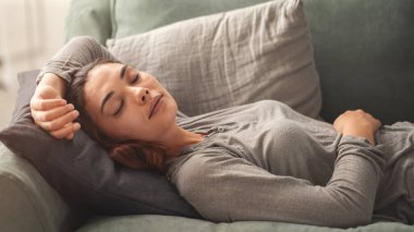 Genç bayan oturma odasındaki kanepede dinlenin.