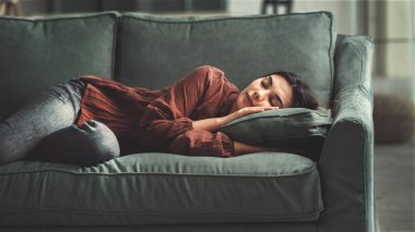Genç bayan oturma odasındaki kanepede dinlenin.