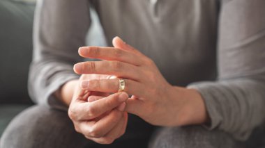 Kadın alyansını çıkarıyor.