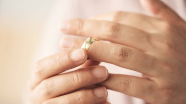 Kadın alyansını çıkarıyor.