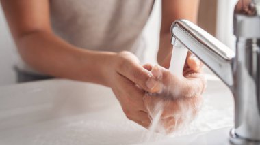 Banyoda ellerini yıkayan bir kadın.
