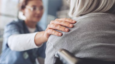 Sağlıklı yaşam tarzı ve tıbbi konsept, sağlık çalışanı yaşlı hastayla konuşur ve onu rahatlatır.