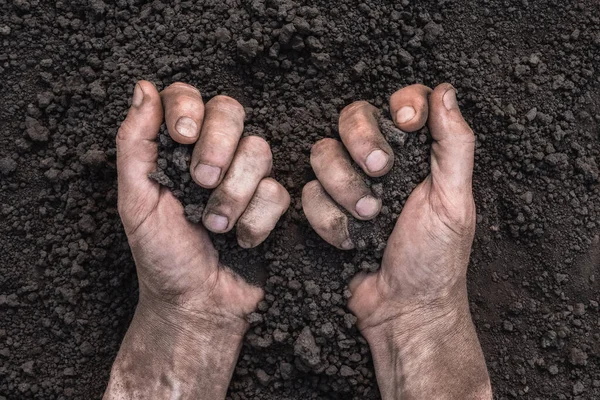 Handful of dirt hands holding soil hands touch the ground. Farmer hands full of soil field organic earth ground. Save the earth day earth save environment day. Fertile soil field agriculture concept