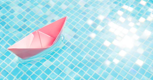 Floating pink paper boat water pool abstract ship symbol. Blue water travel abstract boat travel concept paper ship origami boat toy paper sailboat. Voyage. Dream tours concept dream travel background