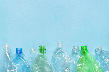 Düz set ezilmiş şişe buruşmuş plastik şişe geri dönüşüm arka plan çöpü plastik PET geri dönüşüm tasarımı mavi kağıt. Boş şişe PET plastik geri dönüşüm konsepti. Tekrar kullan. Kullanılmış. Atık sıralama