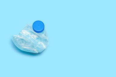 Düz plastik şişe geri dönüşüm dizaynı mavi arka plan. Bir kullanılmış PET plastik geri dönüşüm konsepti. Tek ezilmiş şişe buruşmuş plastik çöp PET geri dönüşüm arka plan görünümü