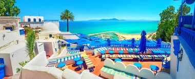 Sidi Bou Said 'de (mavi beyaz şehir) plajlı ve manzaralı açık hava kafesi ve kıyı şeridi manzarası. Tunus, Kuzey Afrika  