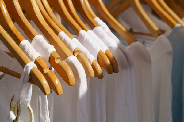 Organic eco clothes on a hanger. Home-made white clothing from natural and processed fabrics, natural vegetable ingredients. Eco-friendly dresses and shirts. High quality photo