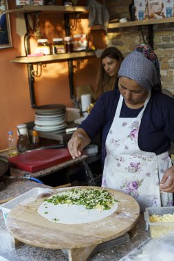 Kash, Türkiye - 21 Kasım 2022: Türk ev hanımı gözleme pişiriyor, geleneksel Türk mutfağı. Peynir ve otlarla doldurulmuş gözlerim. Yüksek kalite fotoğraf. Yüksek kalite fotoğraf