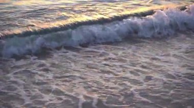 Deniz suyu arka planı. Gün batımında dalgalarla birlikte doğal okyanus suları yüzeyi ve sörf. Deniz kıyısı ve sahil. Yüksek kaliteli FullHD görüntüler