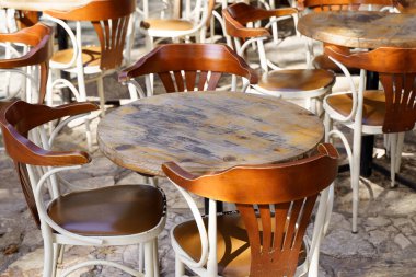 Yazın, turist caddesinde ahşap eski sandalyeler ve masalarla dolu bir sokak kafesi. Ziyaretçisi olmayan boş bir restoran ya da kafe. Yüksek kalite fotoğraf
