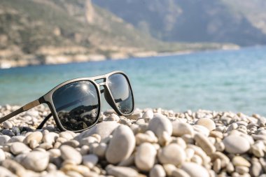 Deniz sahilinde güneş gözlüğü, denizin arka planına karşı. Tatil, rahatlama, yaz konsepti. Yüksek kalite fotoğraf