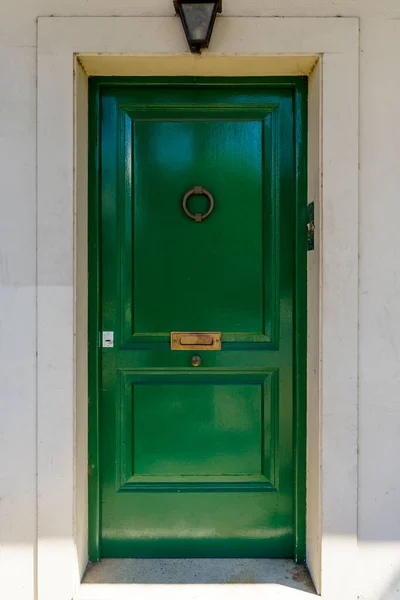Old vintage door. Antique wooden green door background with lock and handle on architecture facade home. . High quality photo