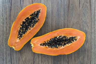 Mutfak masasında dilimlenmiş papaya. Meyveli turuncu papaya yenmeye hazır. Egzotik tropikal meyveler, vegan, sağlıklı gıda konsepti. Yüksek kalite fotoğraf