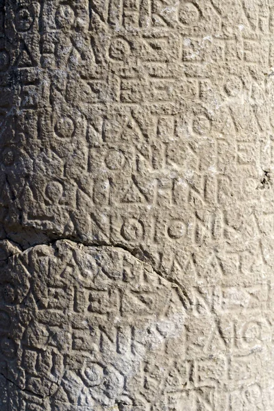 Antique greek inscriptions carved on the stone of the old ruins of an antique greek city. High quality photo