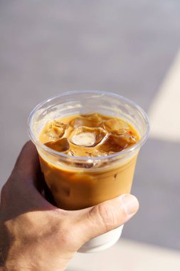  Şehir caddesinde elimde buzlu latte cappuccino kahvesi. Hazır kahve içeceğiz. Yüksek kalite fotoğraf