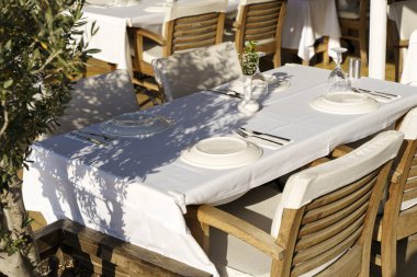 Yazın, turist caddesinde ahşap eski sandalyeler ve masalarla dolu bir sokak kafesi. Ziyaretçisi olmayan boş bir restoran ya da kafe. Yüksek kalite fotoğraf